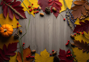 Atmospheric autumn composition with pumpkins and leaves on a wooden background with space for text.