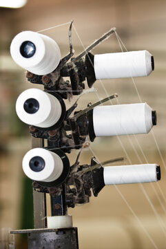 Industria textil, maos consertando os fios nos teares 