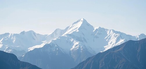 Majestic snow-capped mountain range dominates the background, sharp peaks against a clear sky, earth, blue