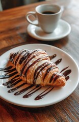 Delicious croissant with chocolate syrup and icing sugar enjoying with coffee