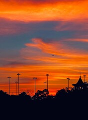 Fototapeta premium Vibrant Sunset with an Airplane and Gazebo Silhouette