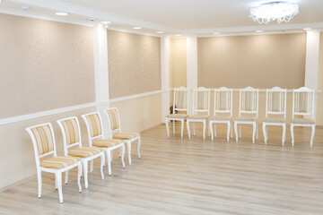 Empty Bright Hall with Rows of White Chairs, Perfect for Events, Gatherings, or Minimalist Interior Design Inspiration.