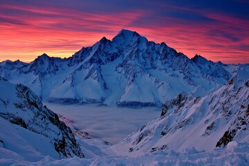Majestic mountain range with vibrant sunset over snow-capped peaks in winter landscape