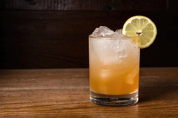 Fototapeta premium Beverage garnished with lemon on a rustic wooden surface. Dining setting. Space for text.