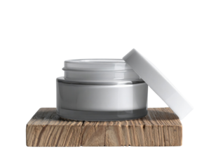 A sleek cosmetic jar rests on a wooden base, showcasing a minimalistic design with a slightly open lid.