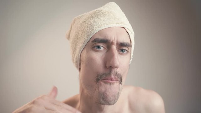 enough stop tie gesture Young handsome attractive man with mustache big eyes wearing a towel on his head, engaging in a humorous performance with playful demeanor and exaggerated facial expressions