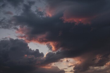 Evening nears with a bold sky of deep clouds streaked with red and orange hues.