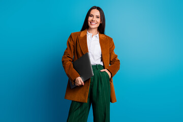 Obraz na płótnie Canvas Charming female professional holding laptop wearing stylish outfit against vibrant background