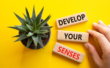 Sense symbol. Wooden blocks with words Develop your Senses. Beautiful yellow background with...