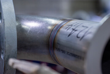 Gros plan sur de la tuyauterie industrielle, montrant les raccords, soudures et la structure métallique.