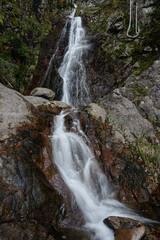 The Cascade de Bockloch in the Vosges, France, flows over rugged rocks, creating a peaceful and scenic natural scene.