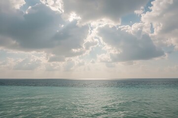 Obraz premium Ocean and sky converge under a cloudy horizon