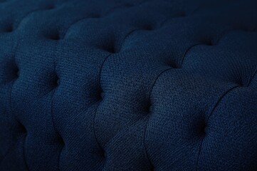 Obraz premium Close-up of tufted fabric furniture with diamond button pattern on dark blue textile background in vintage style