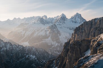 Stunning sight of snowy peaks during winter under a misty sky
