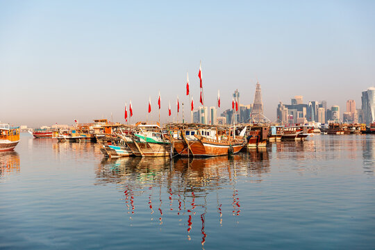 Evening view of Doha Bay with traditional wooden dhow fishing boats along the Corniche, seen from the Museum area in Doha, Qatar &ndash; stock photo.