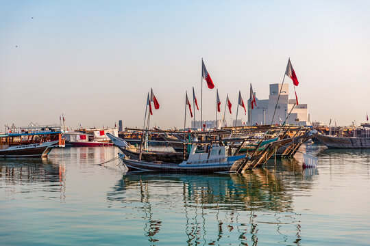Evening view of Doha Bay with traditional wooden dhow fishing boats along the Corniche, seen from the Museum area in Doha, Qatar &ndash; stock photo.