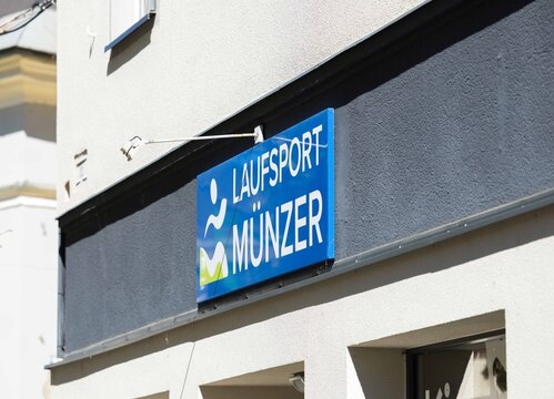 Villach, Austria - September 04, 2025: LaufSport Munzer storefront sign displayed prominently on a building exterior, showcasing a vibrant blue color and inviting atmosphere for sports enthusiasts