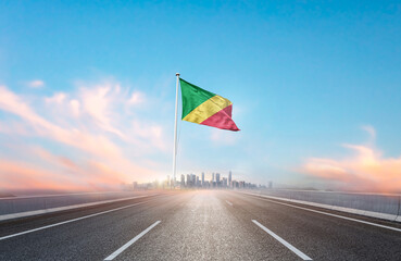 Republic of the Congo national flag with mast waving with beautiful skyline. A view from highway. Republic of the Congo national flag for independence day.