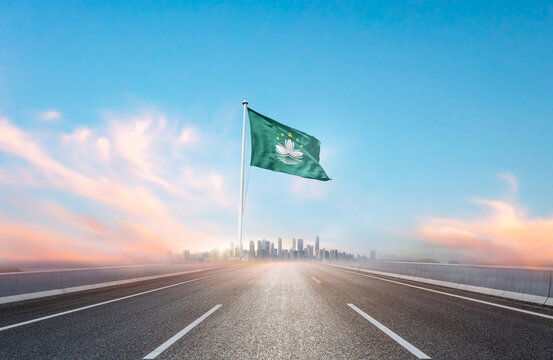 Macau national flag with mast waving with beautiful skyline. A view from highway. Macau national flag for independence day.
