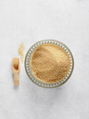 Brown sugar in the glass dishware on the light table, top view, , copy space