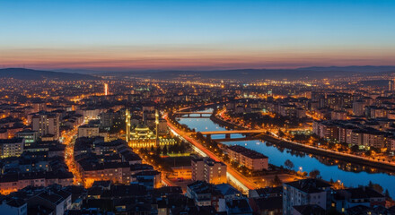 Fototapeta premium Captivating Aerial View of a Cityscape at Twilight With Illuminated Buildings and Reflecting Waterways
