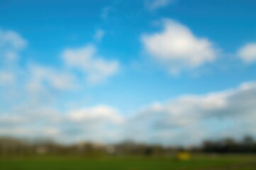 Hazy white clouds drifting across a vibrant blue sky