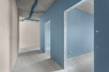 Unfinished renovation in an apartment with drywall partitions and a concrete ceiling.