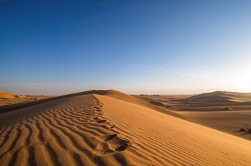 Naklejka premium Stunning sand dunes in a vast desert landscape.