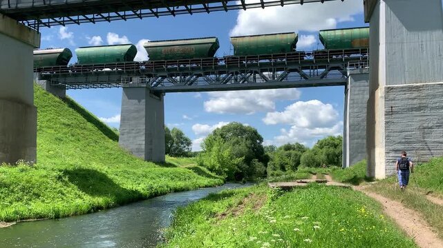 A train carrying freight cars travels across a bridge over a river.