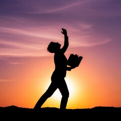 Silhouette of a person holding a book against a vibrant sunset sky