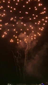 Vertical video. Fireworks on the beach to celebrate the end of the fiesta. Charges fly high into the sky. Mallorca Island. Spain.