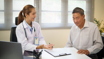 Smiling female doctor explaining diagnosis to older patient in a bright clinic.
