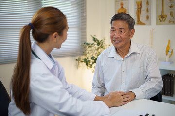 Obraz premium Female doctor showing empathy and support by holding hands with an elderly male patient during a medical consultation.