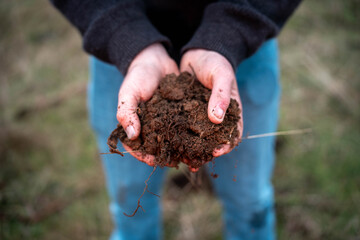 modern young farmer collecting soil samples in a test tube in a field. Agronomist checking soil...