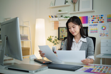 Young creative professional analyzing color palettes and charts during design project.
