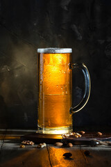 Large glass of beer against illuminated dark wall