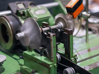 A close-up of a turbocharger turbine compressor wheel and Shaft being balanced on a specialized machine in a workshop.