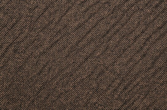 Brown coarse jacquard fabric with diagonal weave texture for upholstery. Macro close-up of textile material used in furniture and wallpaper backgrounds.