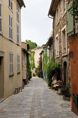 typical street of Grimaud with houses and plants in France in spring