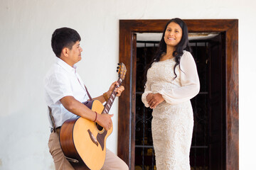 Novios enamorados en vestido blanco, abrazo romántico al aire libre con guitarra y espacio...