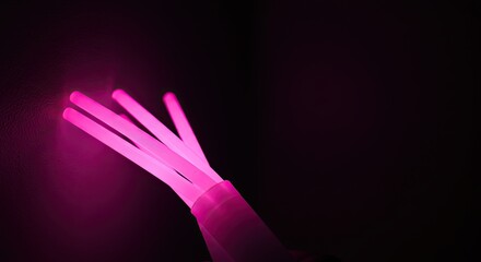 Obraz premium Glowing Pink Fiber Optic Cables Against Dark Backdrop