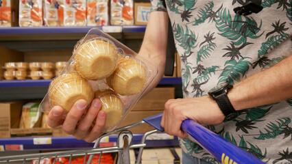 A male customer putting a set of tartlet shells into a shopping cart