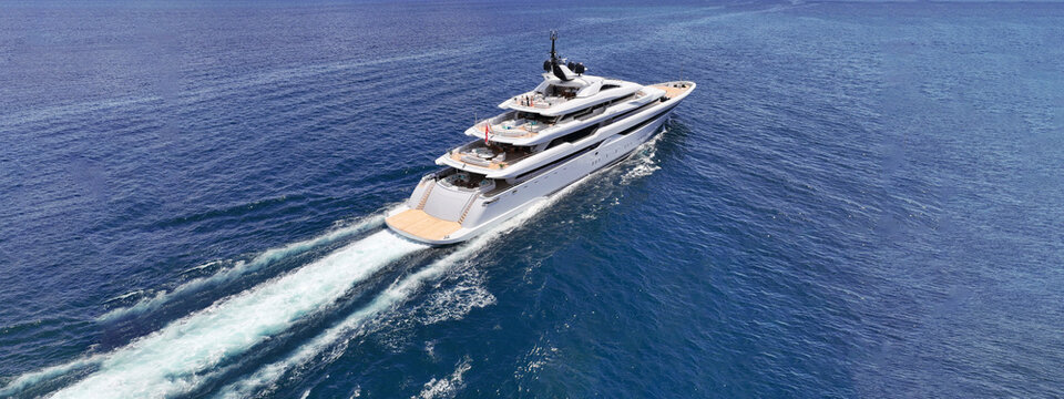 Aerial drone ultra wide tracking photo with copy space of beautiful modern super yacht with wooden deck cruising in high speed deep blue Aegean sea