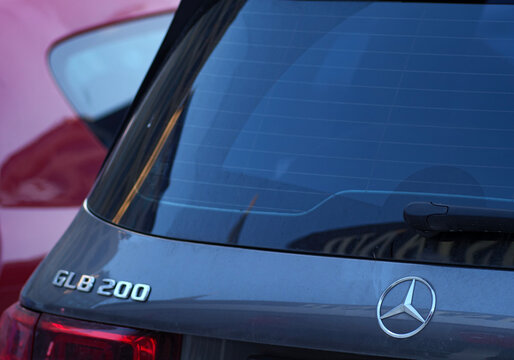 The rear of a dusty grey Mercedes Benz GLB 200 SUV with the iconic three pointed star logo and the model name on the trunk