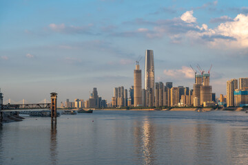 Naklejka premium Wuhan Yangtze River China city skyline towers construction river boats water calm sky clouds day