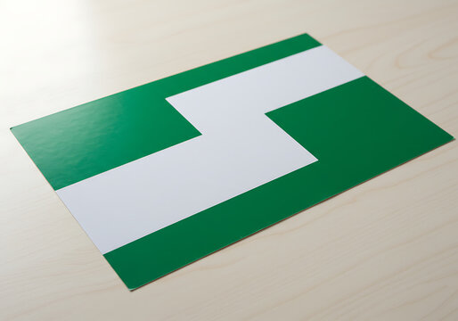 A green rectangular card with a white S-shaped line lying on a light wooden surface.