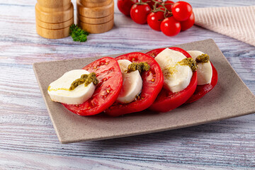Italian Caprese salad with tomato, mozarella and pesto