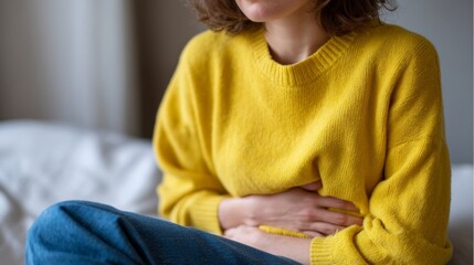A Caucasian woman in bright yellow ponders wellness amidst gut health challenges, hinting at World Digestive Health Day