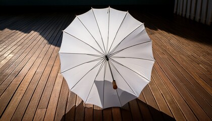 white umbrella open on wooden floor with light shadows