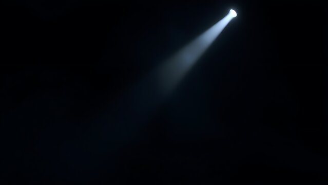 A dramatic stage spotlight cutting through a smoky atmosphere in deep darkness.